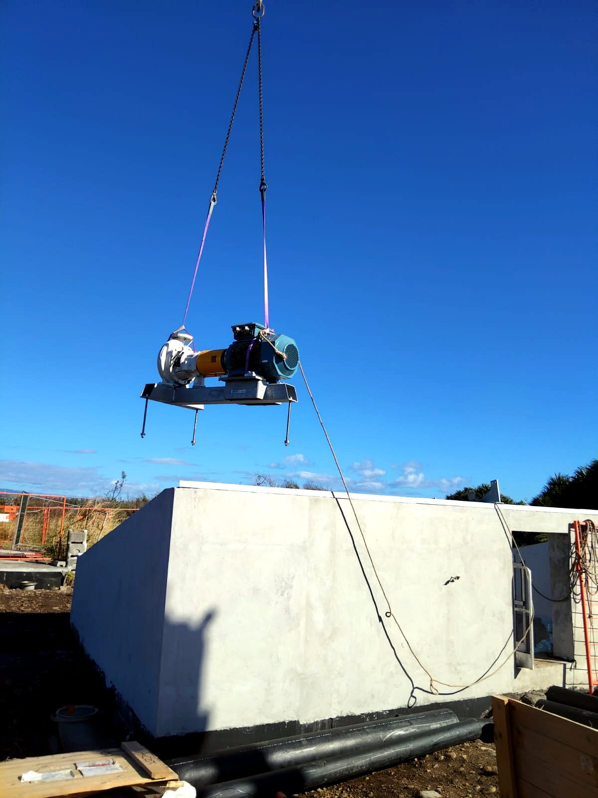 Pose d'une pompe à la grue sur un ouvrage d'assainissement à La Réunion